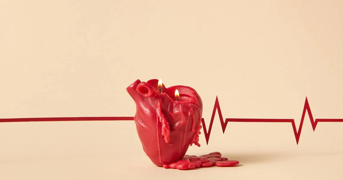 Creative heart-shaped candle melting with lit flames, against a backdrop of an ECG line symbolizing heartbeat.