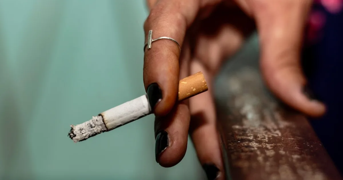 a person holding a cigarette in their hand